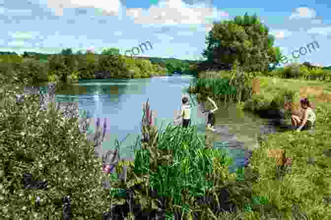 A Tranquil Stretch Of The River Thames, With Lush Meadows And Trees Along Its Banks. The Historic Thames Hilaire Belloc